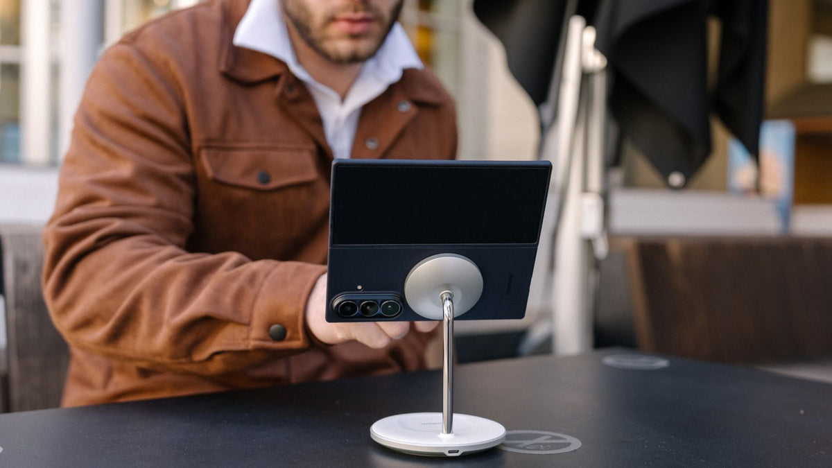 Guy in brown jacket facing Galaxy Z Fold 7 in black Thinborne case attached to a MagSafe stand