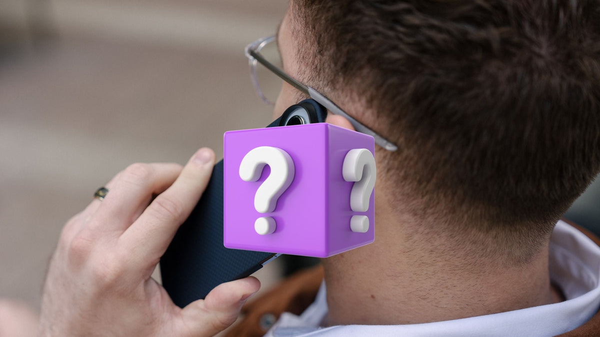 man appears to be on the phone with purple mystery box in the center, covering the rumored new iphone