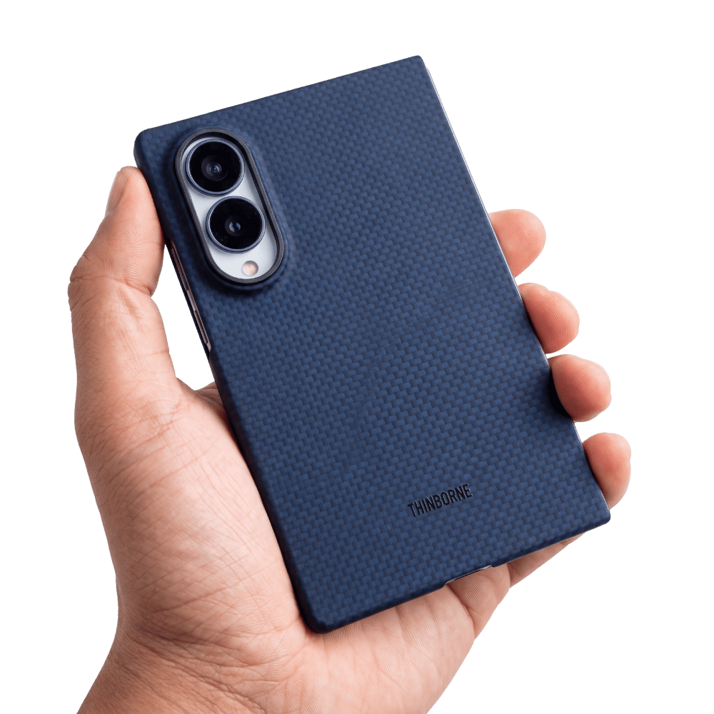 A hand holding a dark blue samsung galaxy z fold 8 phone case with a carbon-fiber-like pattern and a visible THINBOONE logo near the bottom, shown against a plain white background.