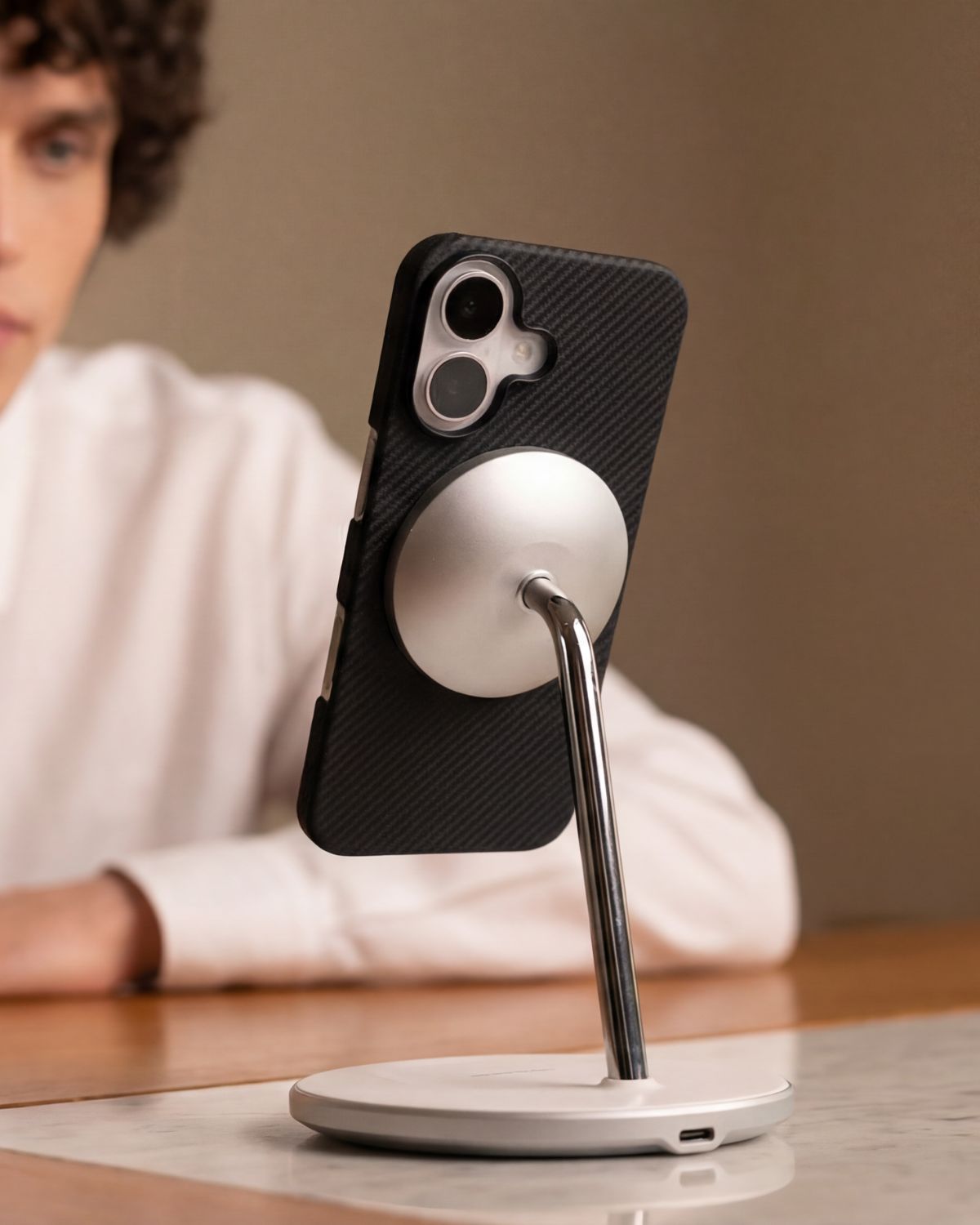 iPhone 17 case with stand on a desk, person in the background