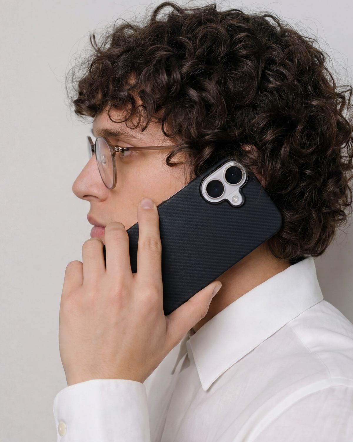 Person holding a black iphone 17 case with a white background