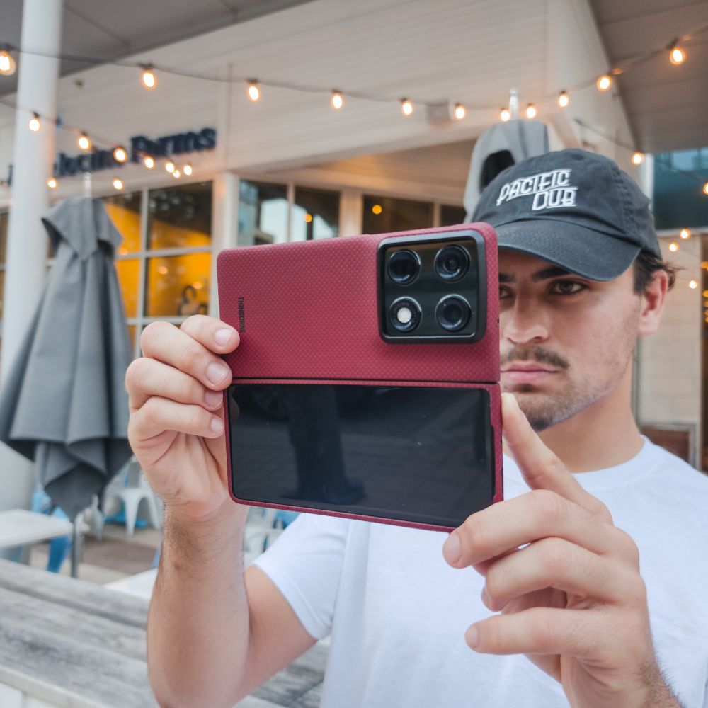 a man holding unfolded motorola razr fold with aramid fiber case to take photo