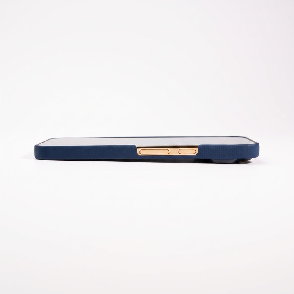 A close-up side view of a pixel 11 pro xl in a navy blue aramid case with rose gold button accents, set against a plain white background.
