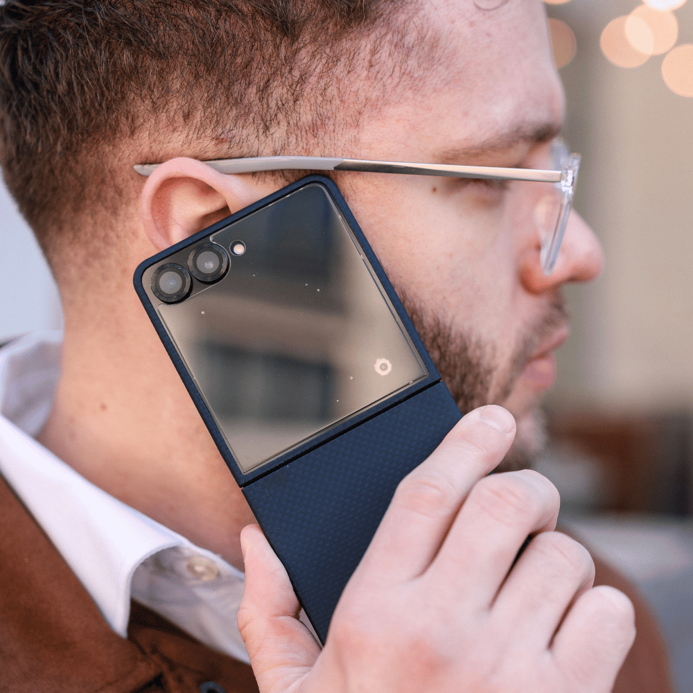 galaxy z flip 8 case in navy blue aramid fiber being held up to a user's ear during a phone call, showcasing the slim form factor.