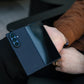Hands holding a partially folded Samsung Galaxy Z Fold 8 Ultra in a navy blue aramid fiber case, showing the camera module and front screen.