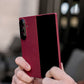 Person holding a red galaxy z fold 7 case with a blurred background