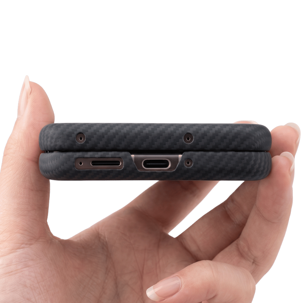 A close-up of a hand holding a slim black carbon-fiber-textured motorola razr ultra 2026  phone case from the bottom edge, showing two USB-C ports and small camera cutouts against a white background.