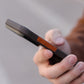 Hand holding a iPhoone 17 pro max on a phone with a textured case to show the thinnest of the design