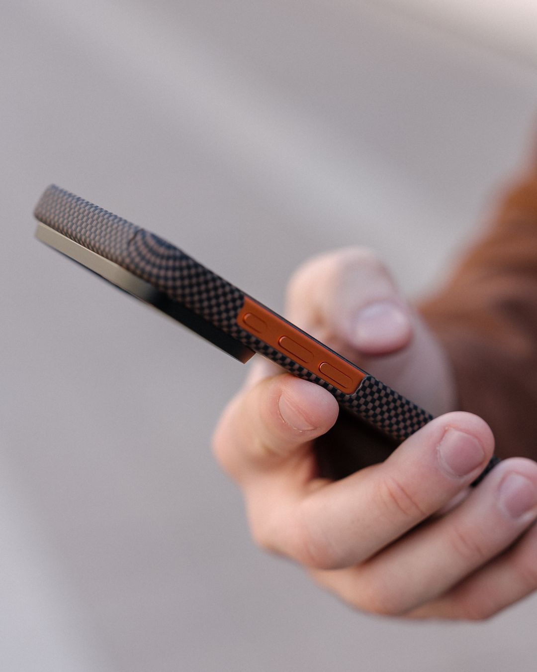 Hand holding a iPhoone 17 pro max on a phone with a textured case to show the thinnest of the design