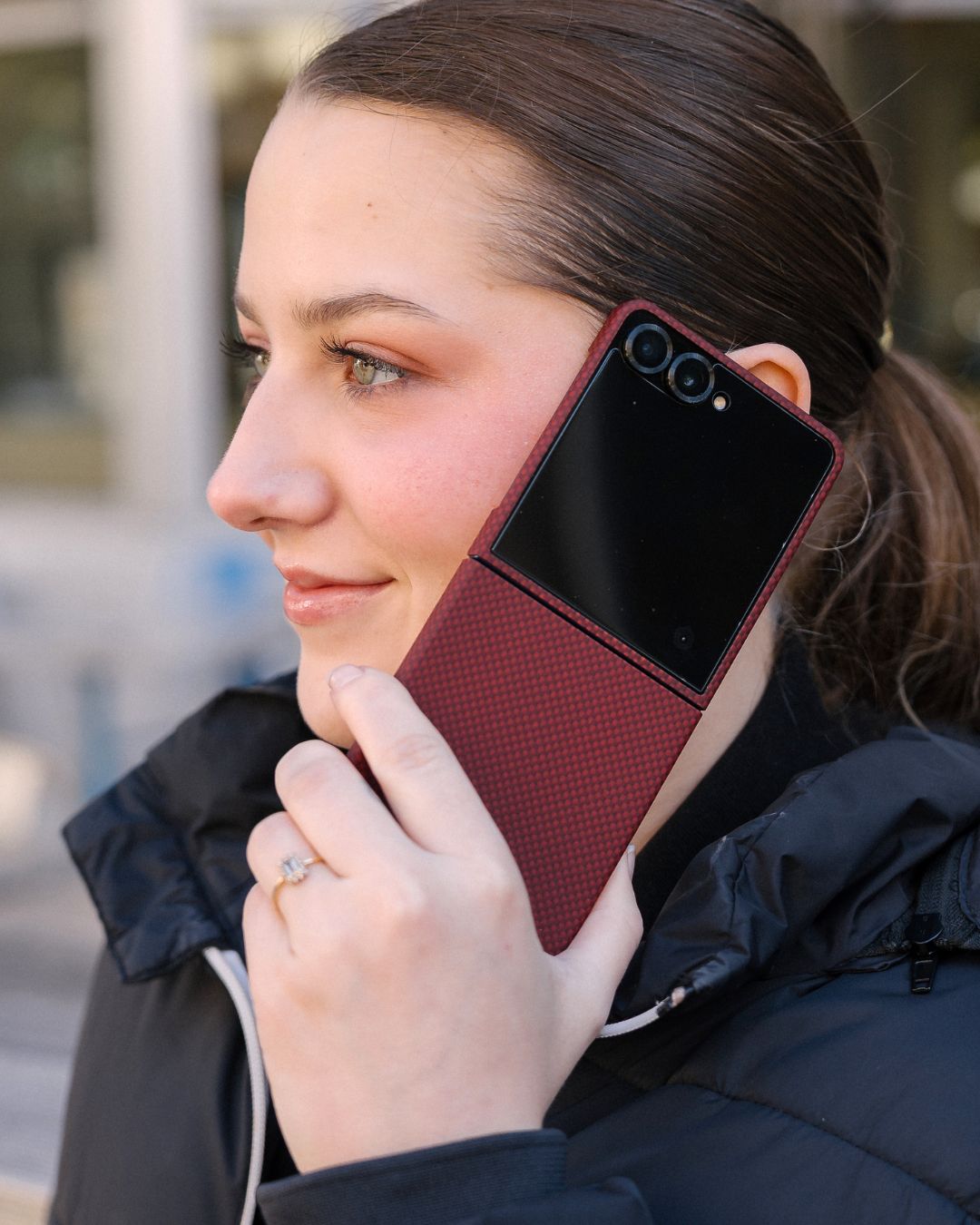 woman holding a red galaxy z flip 7 phone case with a textured pattern