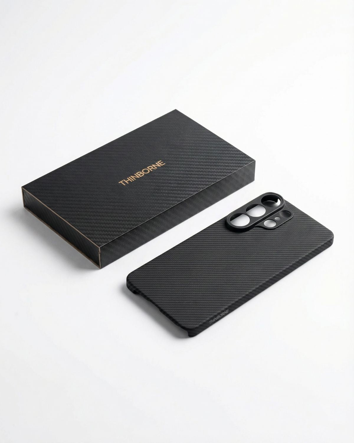 Black galaxy s26 ultra phone case with carbon fiber texture and matching box on a white background