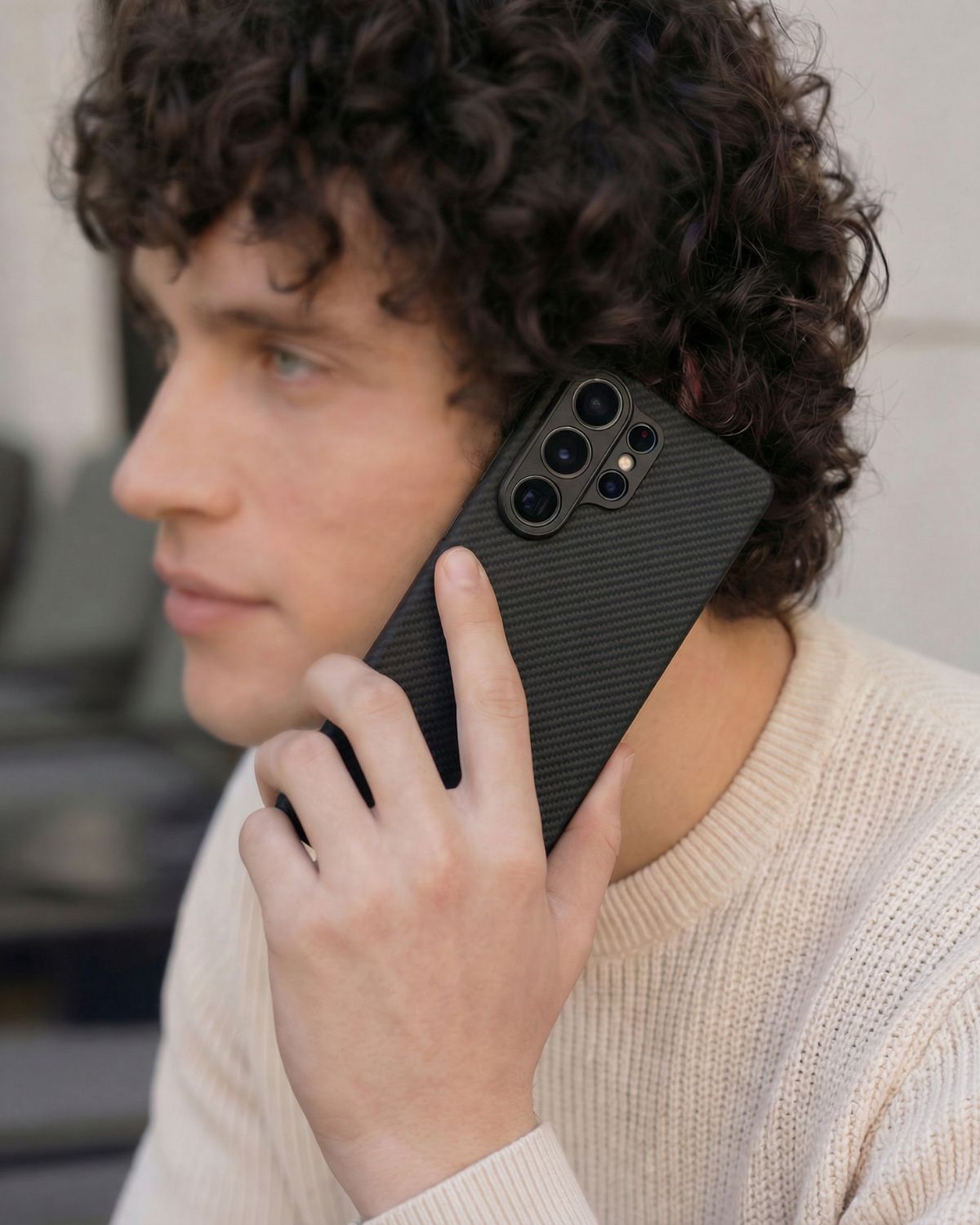 Person holding a black samsung galaxy s26 ultra phone case with a textured design