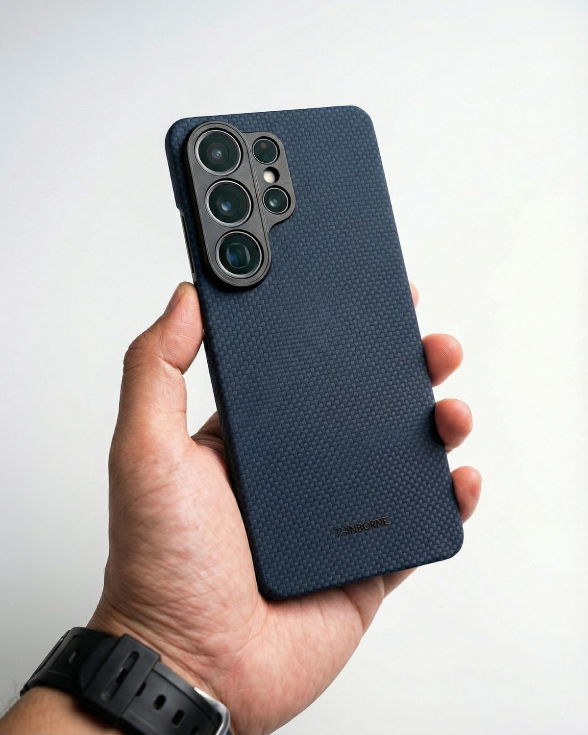 Hand holding a blue textured galaxy s26 ultra thin case with a white background