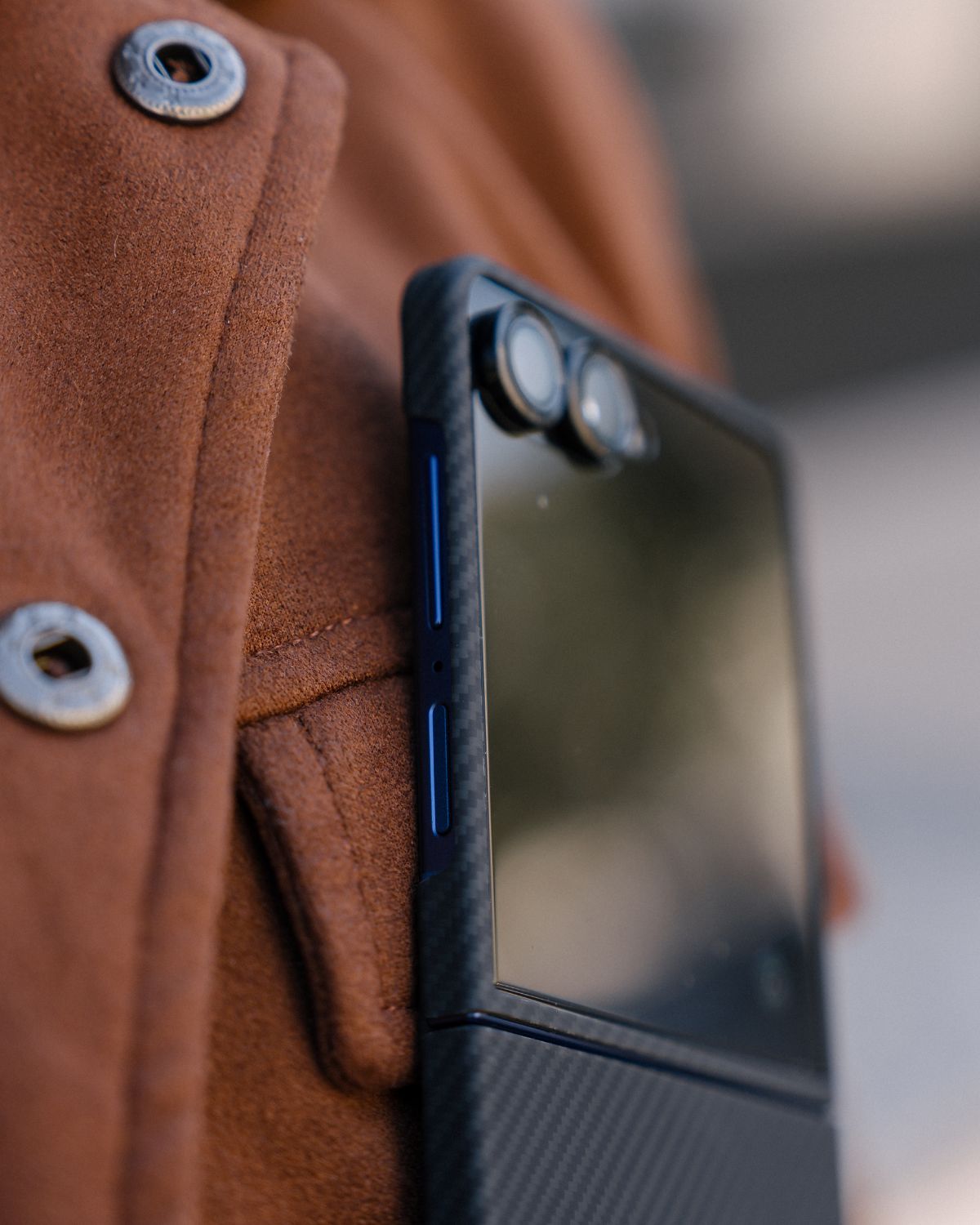 galaxy z flip 7 with carbon fiber case held against a brown textured surface