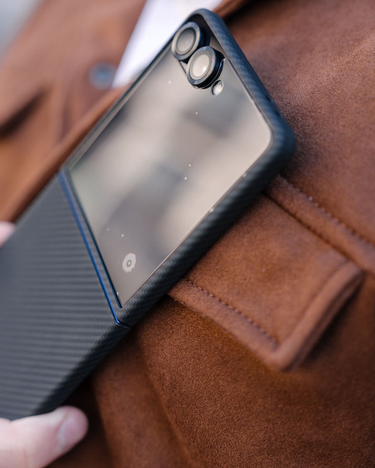 galaxy z flip 7 case being held over a brown leather surface
