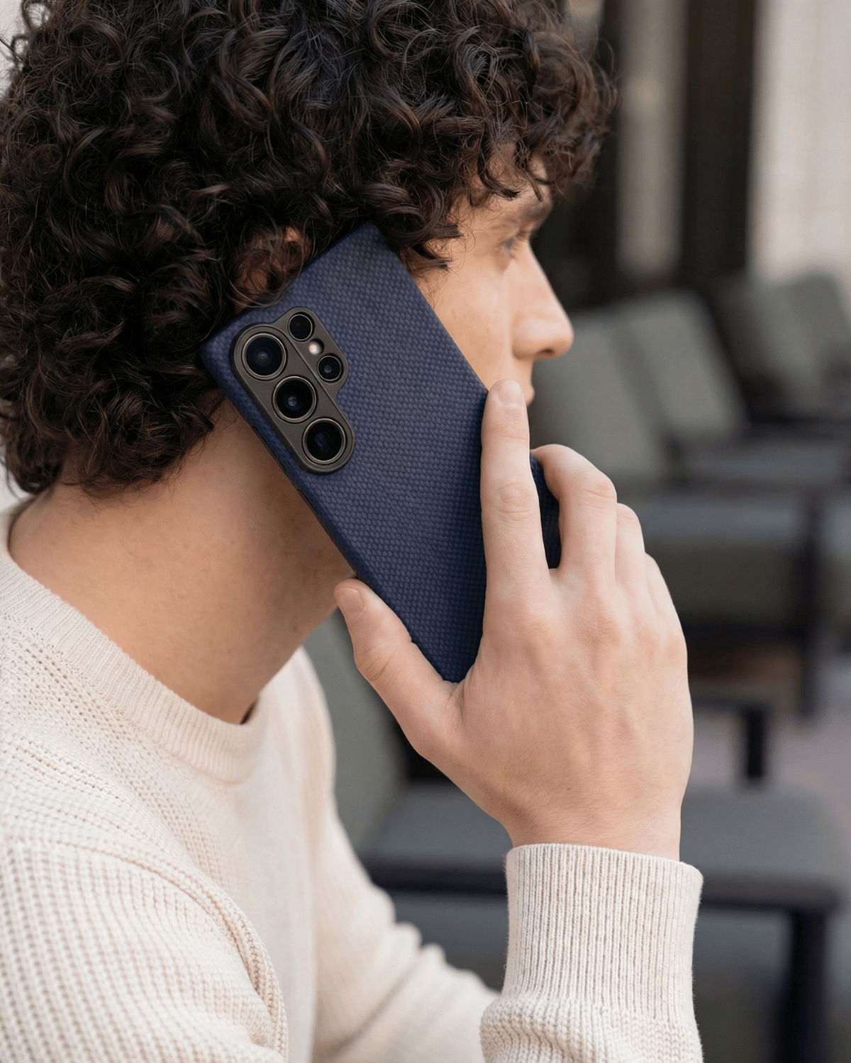 Person holding a galaxy s26 ultra blue phone case with a blurred background