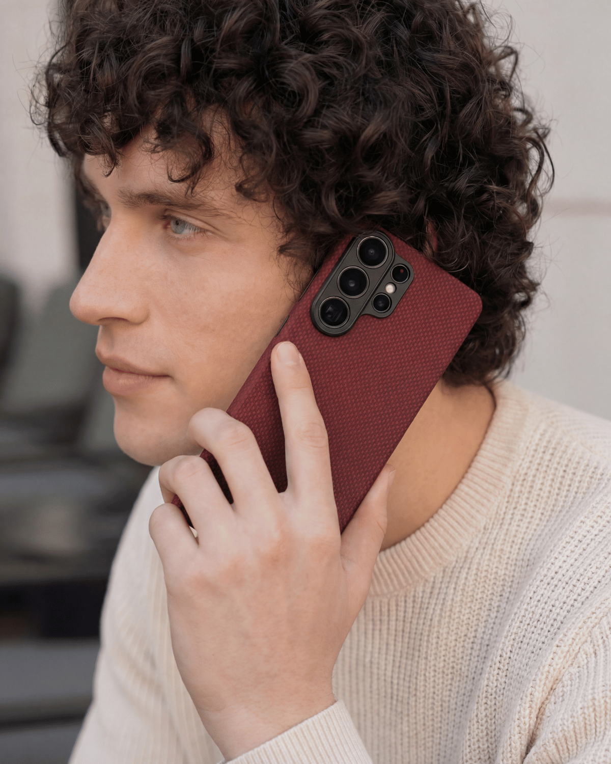 Man holding a red samsung s26 ultra case case with a blurred background