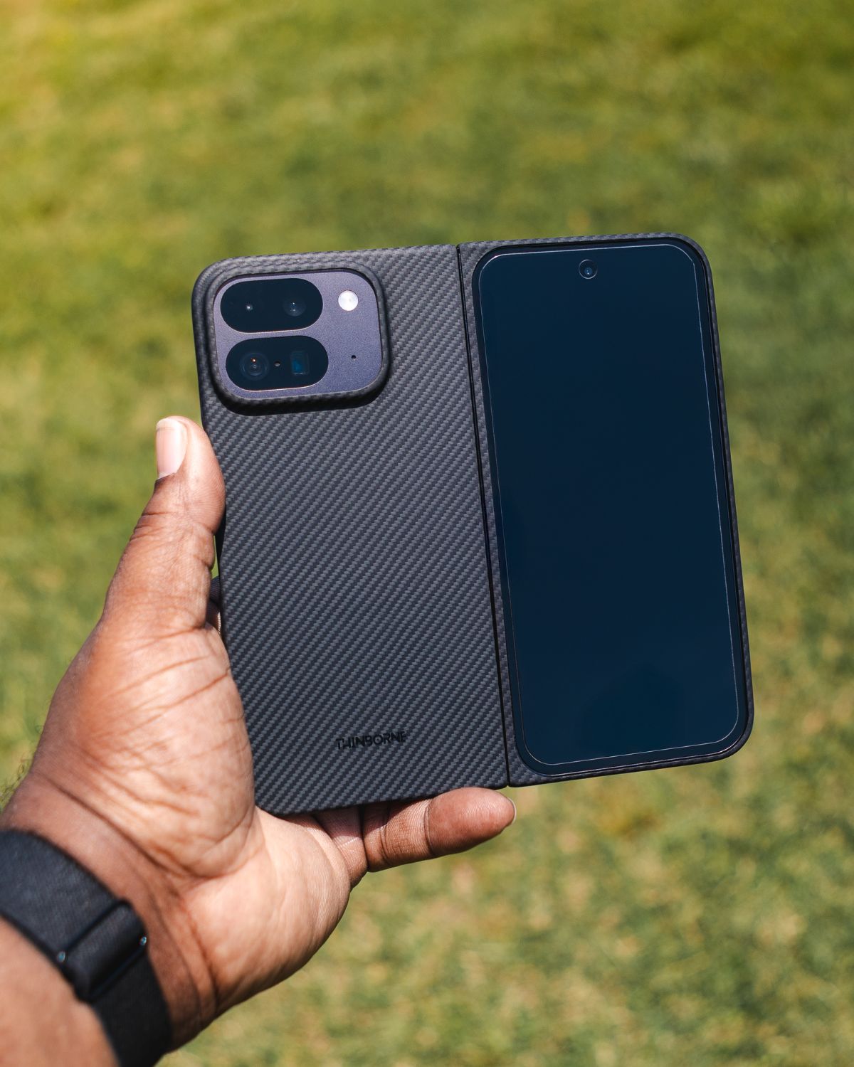 Pixel 10 Pro Fold case held outdoors, showing slim aramid fiber design, front cover protection, and premium finish.
