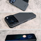A composite image showing a black iPhone case on a concrete background from three different angles, highlighting the camera cutouts and side buttons.