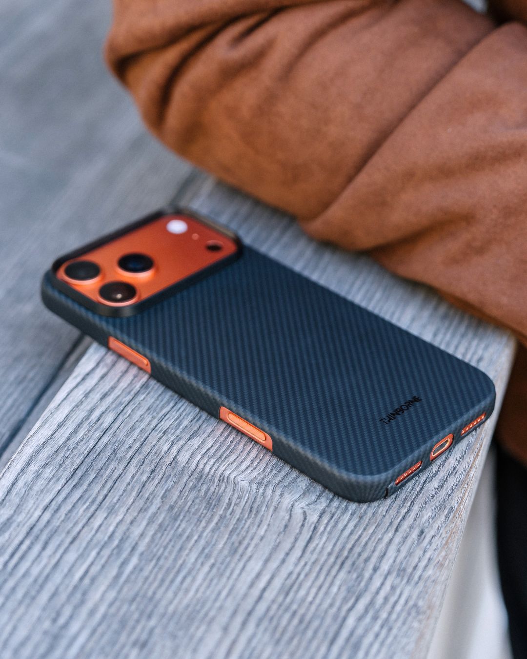 a black iphone 17 pro max case with phone laying on a surface