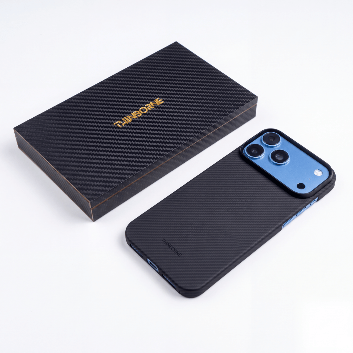 Thinborne iPhone 18 Pro Max aramid fiber case displayed beside its premium carbon fiber textured packaging, showing the case’s slim profile, camera surround, and detailed craftsmanship