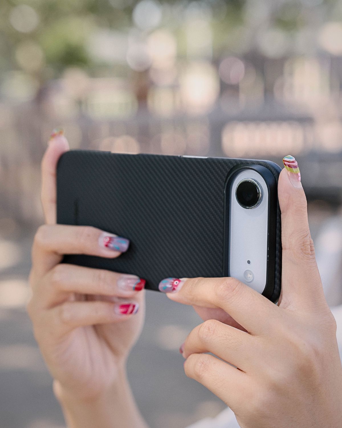 A person holds the phone sideways in both hands, taking a photo.