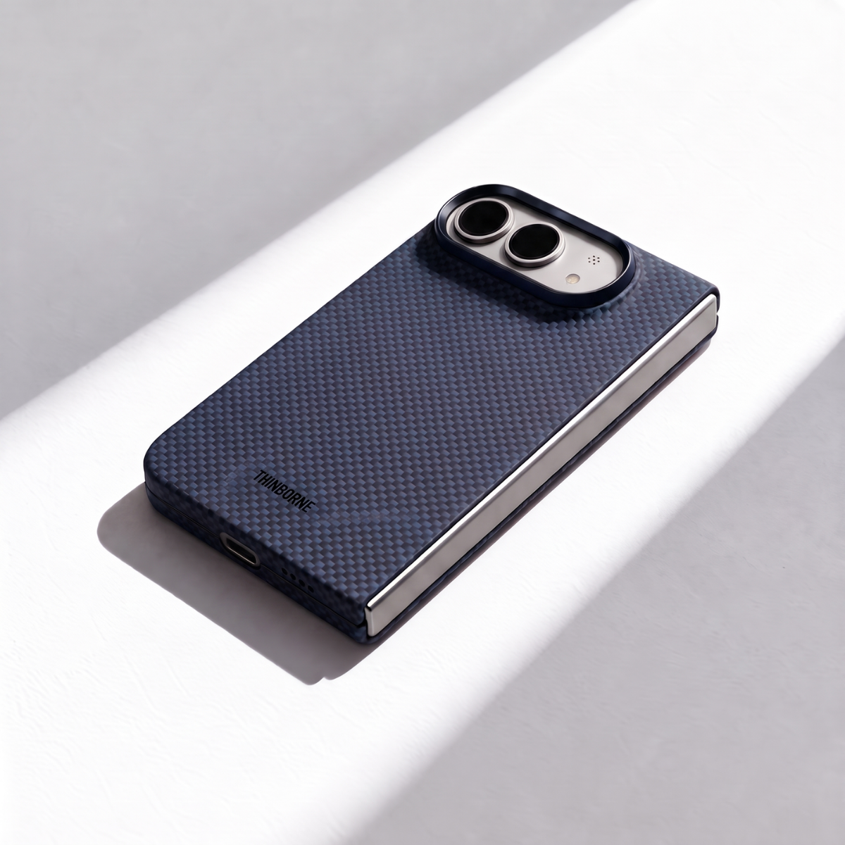 A dark navy blue carbon fiber iphone duo phone case with a silver metal edge, shown on a smartphone.