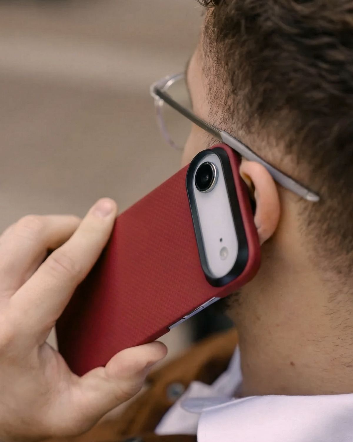 Person holding a red iphone air case to their ear