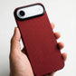Red textured iphone air case held in a hand against a white background