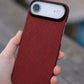 Red textured iphone air case held in a hand with a blurred background