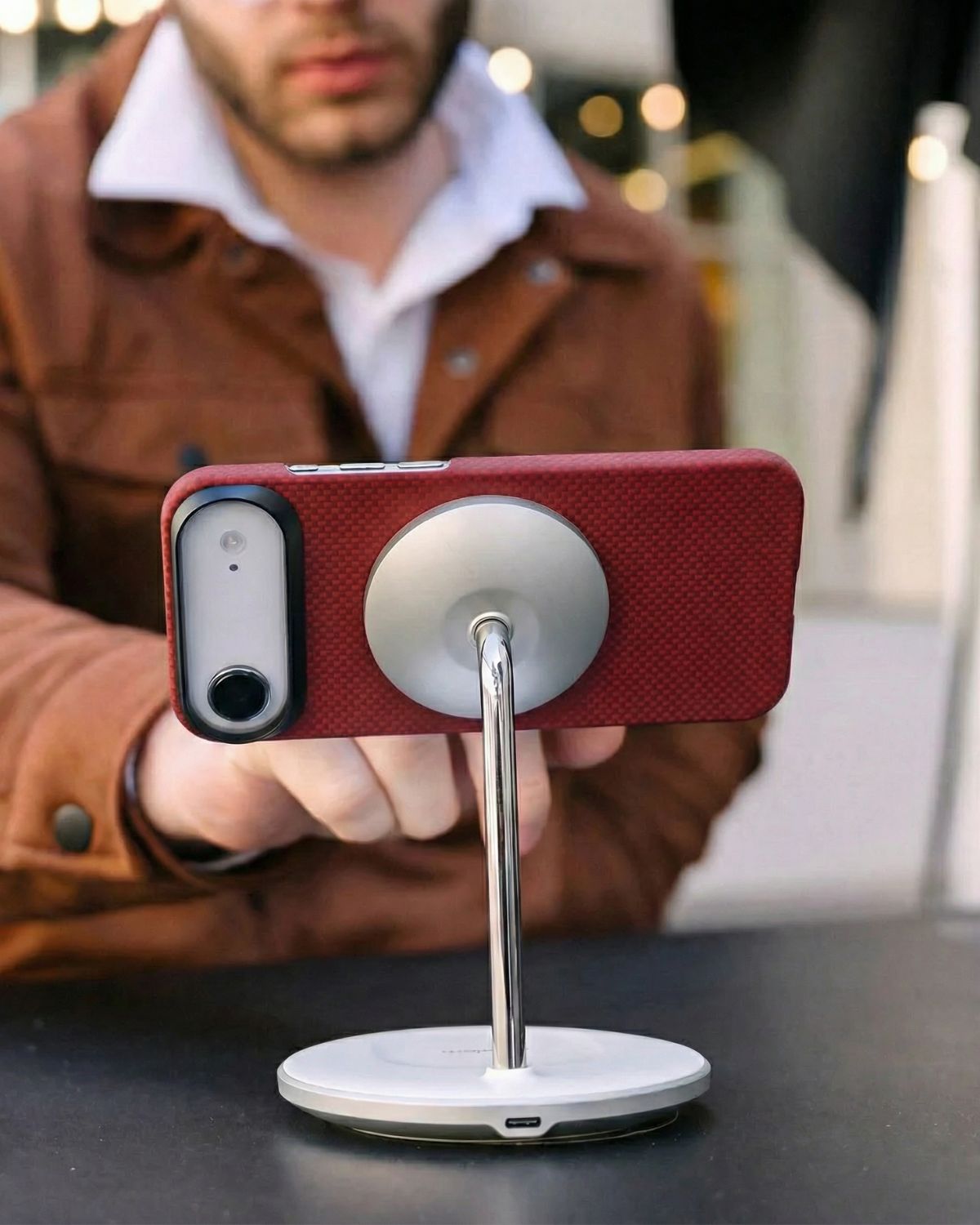 Person holding a smartphone with a iphone air case attached to a magsafe stand