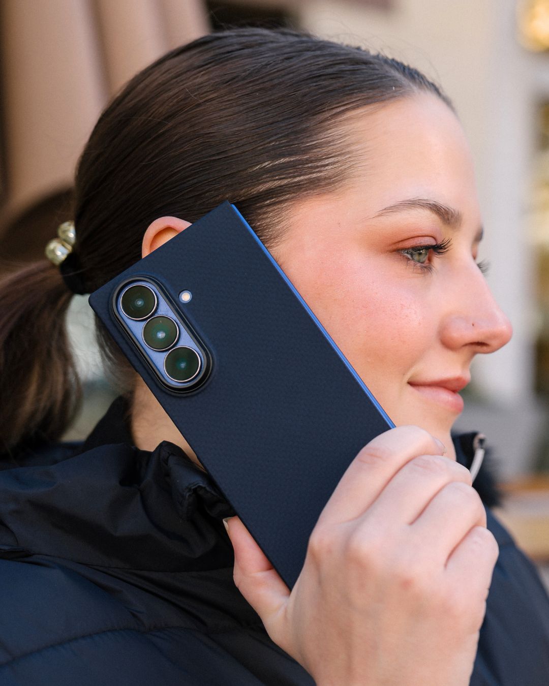 Woman holding a blue phone with galaxy z fold case with a blurred background