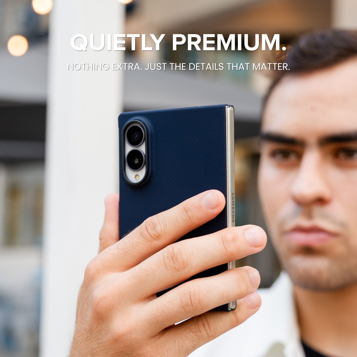 a man holding galaxy z fold 8 with navy aramid fiber case 
