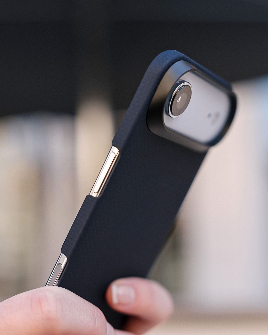 iPHONE AIR phone case being held with a blurred background