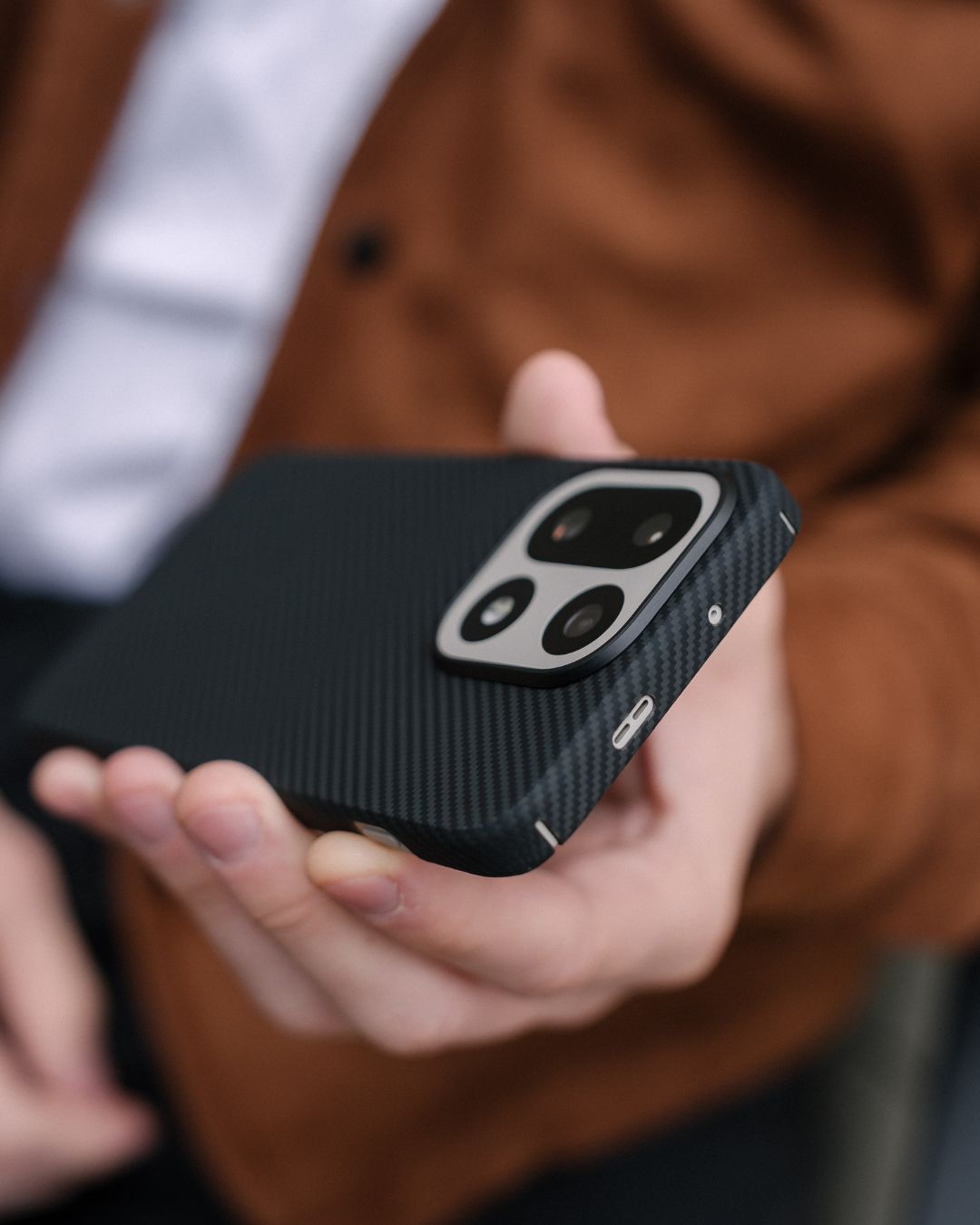 Close-up of a textured black OnePlus 15 protective case featuring a premium twill weave pattern and raised camera protection.
