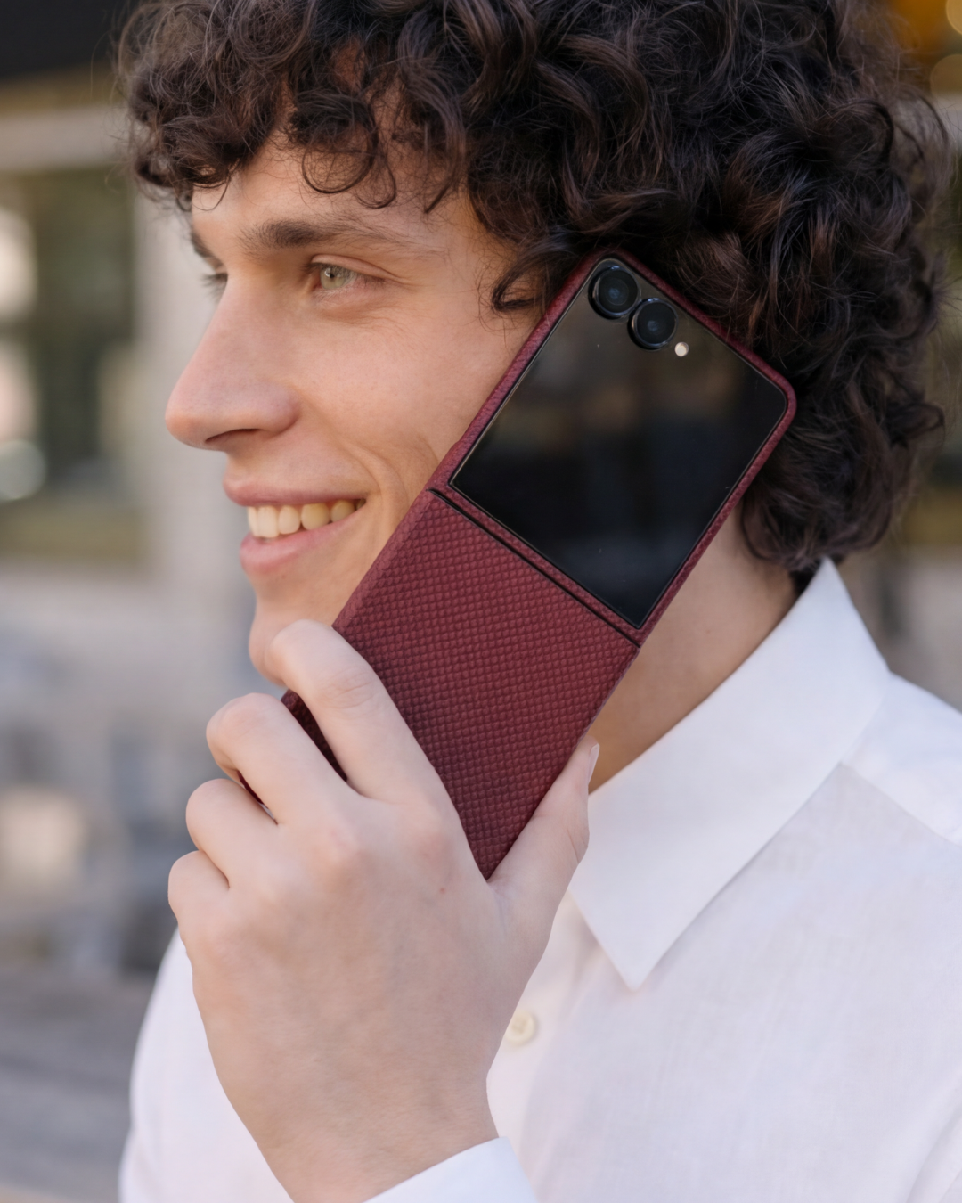 Man holding a red galaxy z flip 7 phone case with a textured pattern