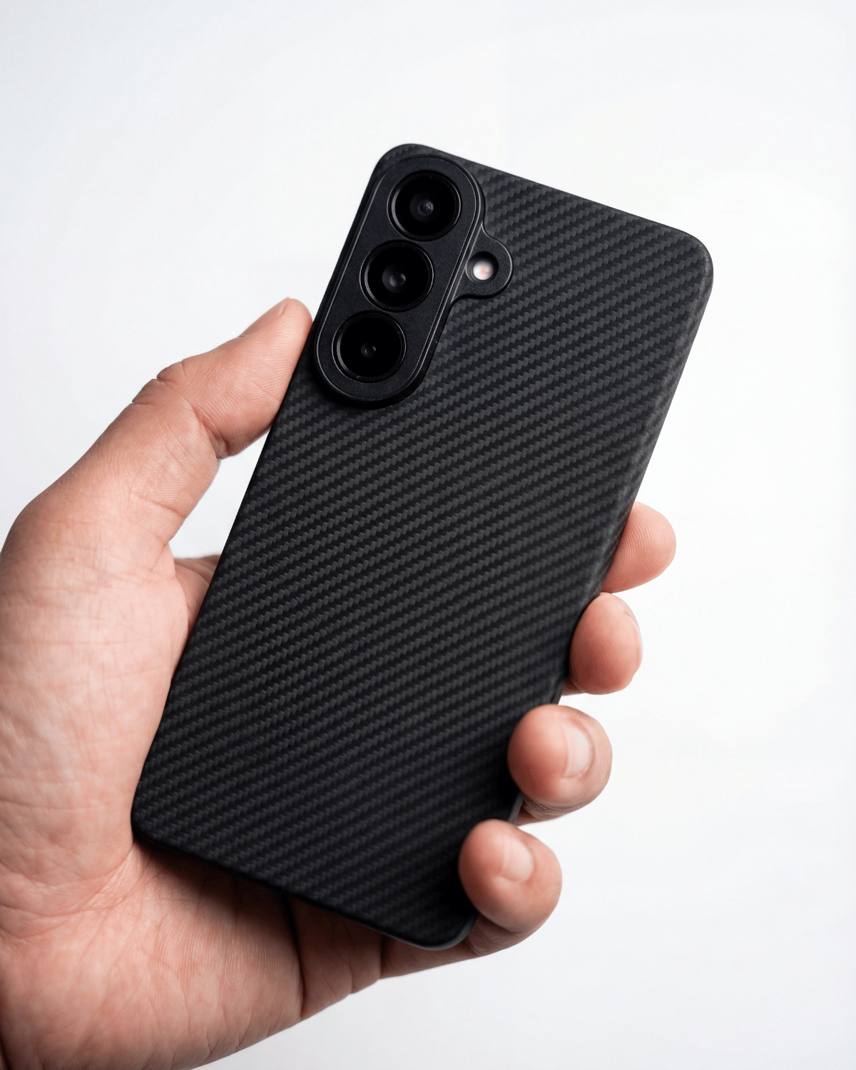 Hand holding a black thin galaxy s26 plus case against a white background