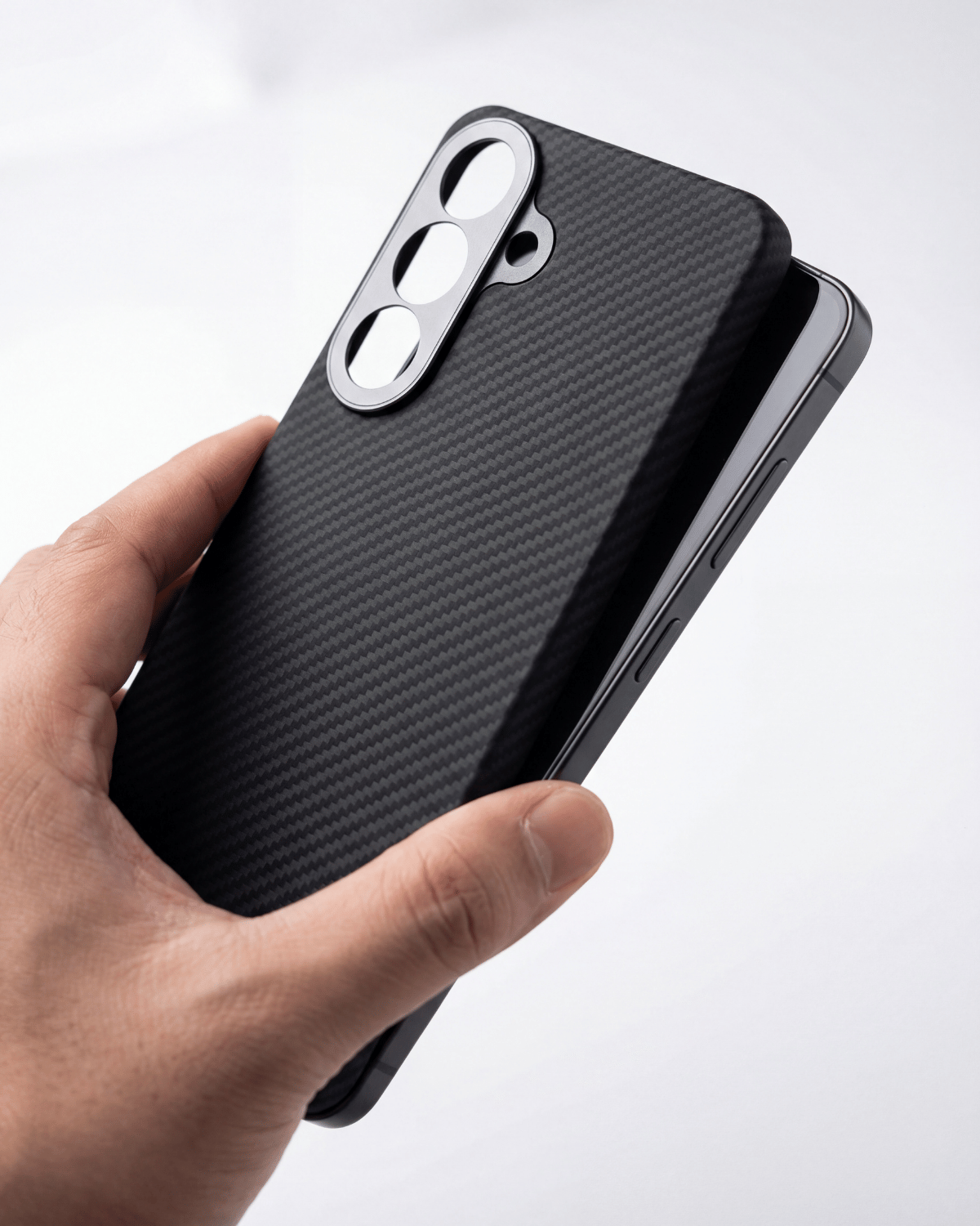 Hand holding a black s26 plus case with a textured finish on a white background